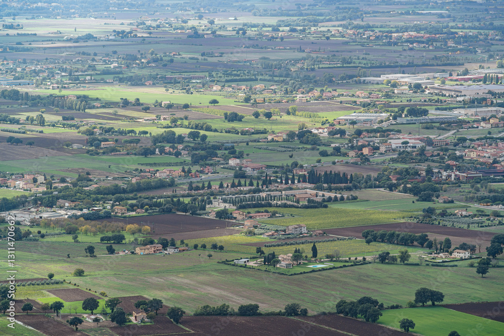Fototapeta premium A large field with a few houses in the distance in Gubbio Viewpoint Italy Umbria