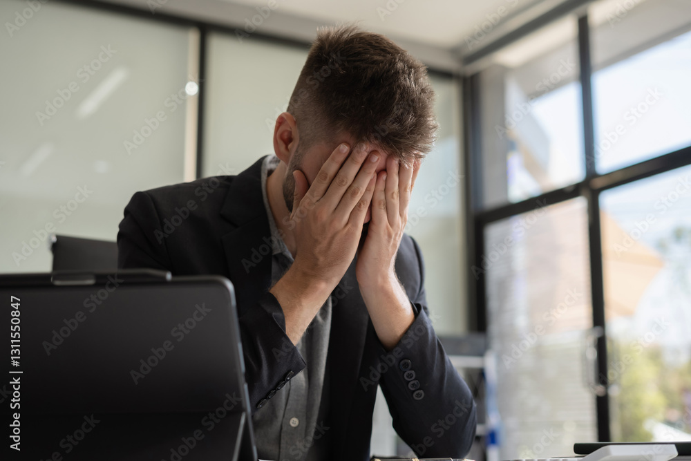 Businessman male stressed over credit card debt monthly expenses in office. Businessman male stressed over credit card debt monthly expenses in office.