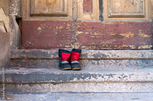 Old children's shoes in an abandoned house entrance on the stairs art design