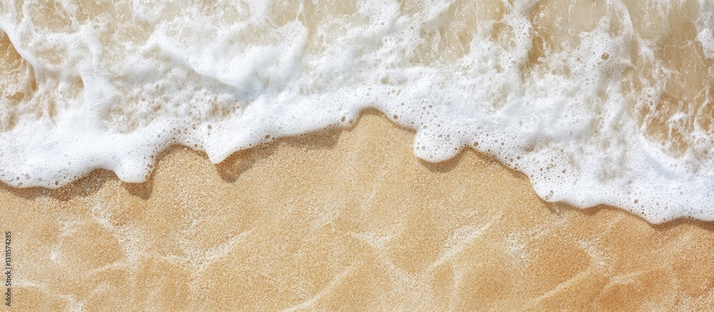 Top view of smooth golden sand with gentle white waves forming patterns; a minimalist beach scene ideal for summer travel and relaxation themes.