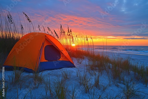 Beautiful sunset over the beach with tall grass and sand dunes.