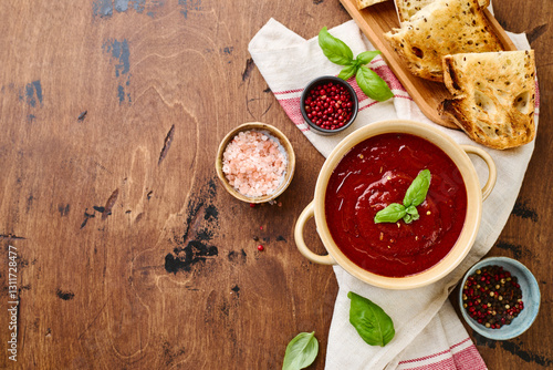 Wallpaper Mural Tomato puree soup garnished with basil leaves and spices in ceramic bowl with toasted bread slices on wooden table Torontodigital.ca