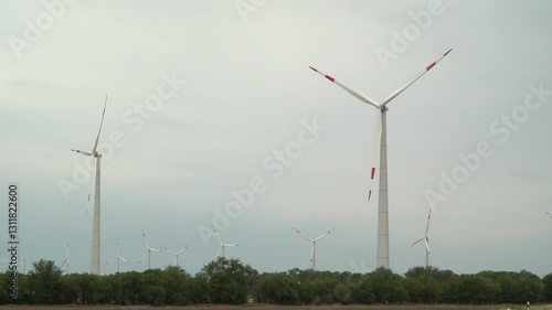 A wind turbine operates in a forest belt