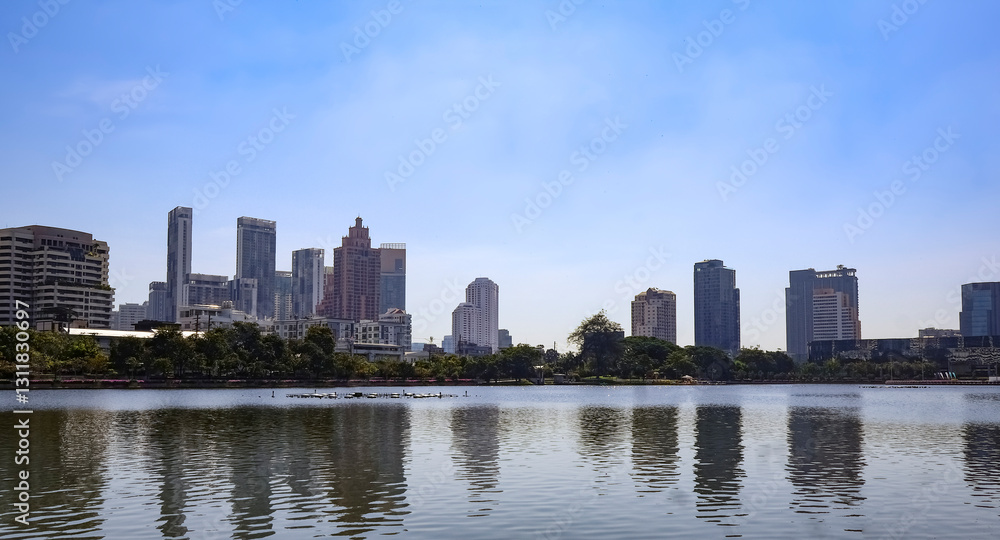 Beautiful Benchakitti Park, skyscrapers against the backdrop of a reservoir and palm trees, open public space, Bangkok City Skyline, Thailand Beautiful Benchakitti Park, skyscrapers against the backdrop of a reservoir and palm trees, open public space, Bangkok City Skyline, Thailand
