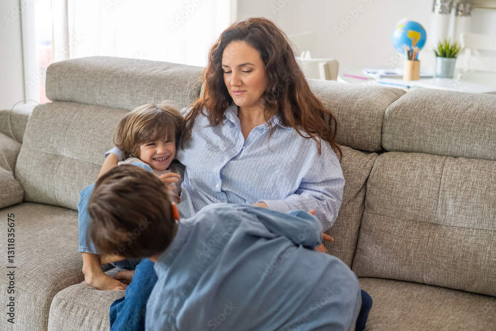 Two cheerful children are playing with their mother on a comfortable sofa in their living room, enjoying a joyful and playful family moment together Two cheerful children are playing with their mother on a comfortable sofa in their living room, enjoying a joyful and playful family moment together