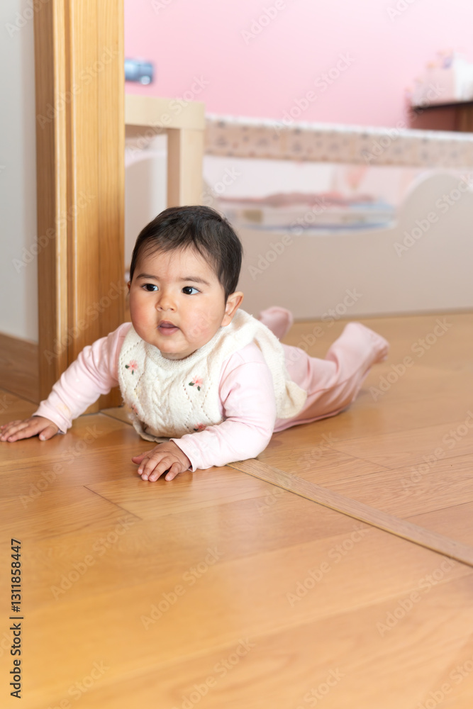 Chubby baby girl exploring her environment learning to crawl crawls with arms in her pink room, Close-up. Chubby baby girl exploring her environment learning to crawl crawls with arms in her pink room, Close-up.