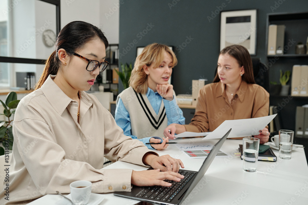Obraz premium Side view portrait of young Asian businesswoman using laptop computer in office during business meeting with all female team copy space