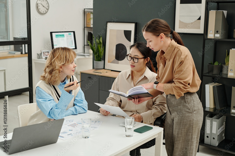 Obraz premium High angle view at all female business team collaborating on work plans during meeting in modern office