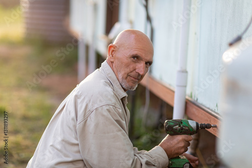 man doing maintenance with cordless drill photo