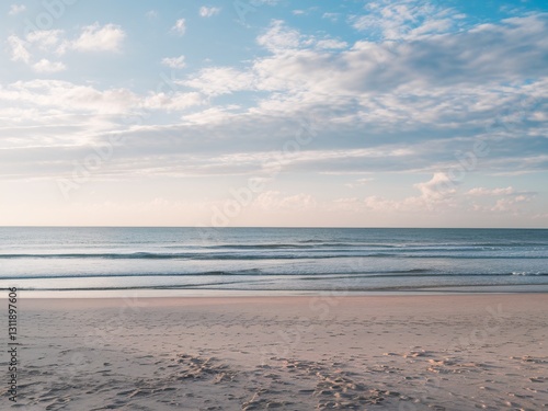 Serene beach view with gentle waves and soft clouds, evoking tranquility and peace.