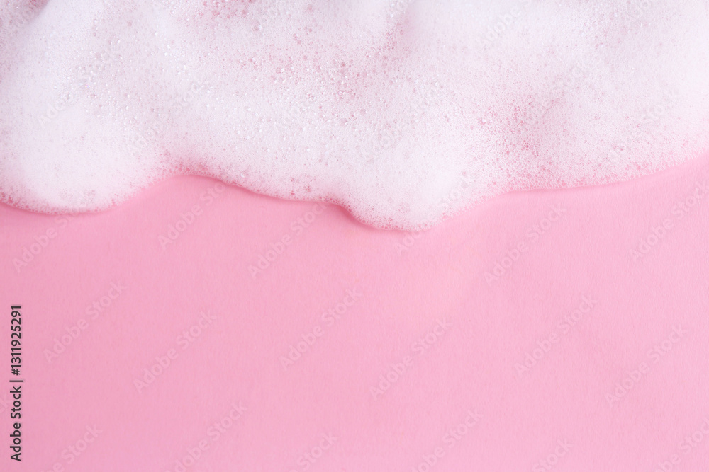 Fototapeta premium Sample of fluffy foam on pink background, top view. Space for text