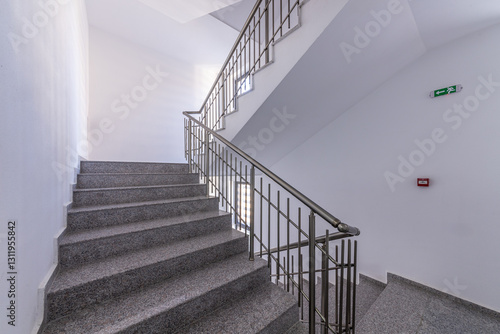 Modern stair case between floors. Stairs with metallic rail in modern building