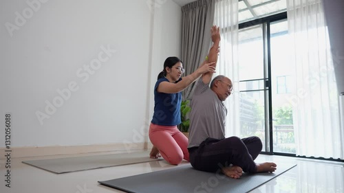 Asian senior enjoys routine stretching exercises at home with woman assistance, promoting health and mobility in a calm, inviting space.