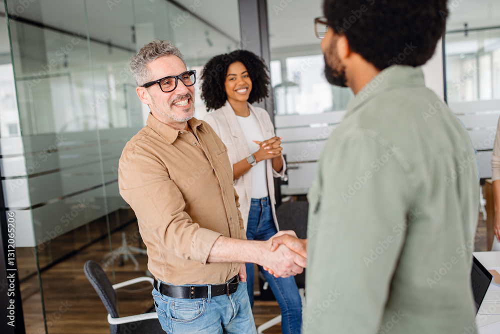 A professional handshake between two business colleagues in a modern office. Smiling coworkers observe, symbolizing agreement, teamwork, and successful partnership in a collaborative work environment. A professional handshake between two business colleagues in a modern office. Smiling coworkers observe, symbolizing agreement, teamwork, and successful partnership in a collaborative work environment.