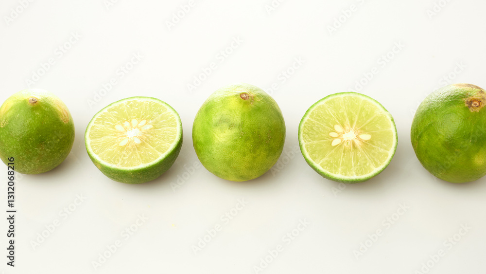 Limes Isolated in White Background Arranged in a Line Showcasing Whole and Sliced Varieties Limes Isolated in White Background Arranged in a Line Showcasing Whole and Sliced Varieties