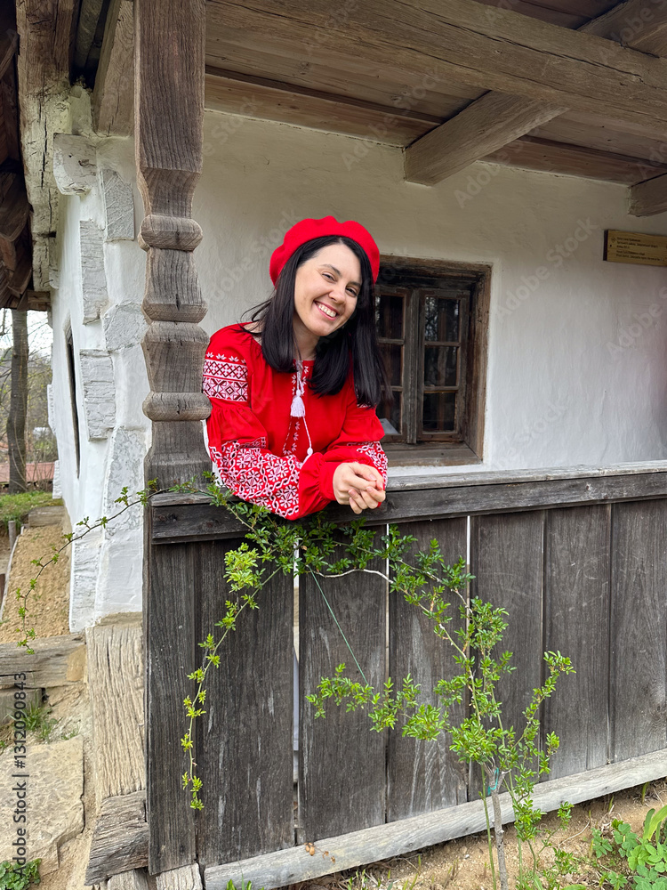 Smiling Woman in Traditional Red Outfit by Rustic Window