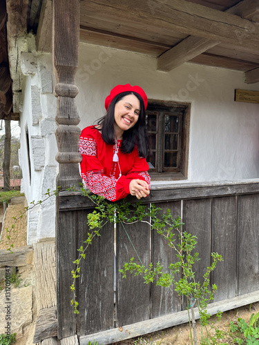 Obraz na płótnie Smiling Woman in Traditional Red Outfit by Rustic Window w salonie