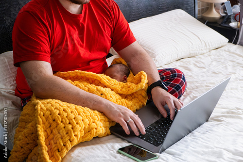 Obraz na płótnie Man multitasking with laptop and baby on bed w salonie