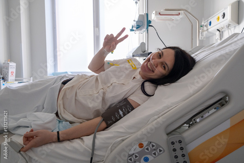 Obraz na płótnie Smiling Patient in Hospital Bed Making Peace Sign w salonie