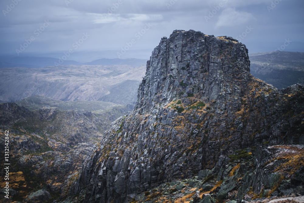 Rugged rocks in the Serra da Estrela mountain range, Portugal, under overcast skies in autumn, creating a dramatic and moody atmosphere.