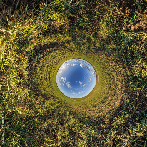 blue hole sphere or globe little planet inside grass or sand or dry ground frame background with tractor tracks photo