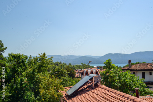Close-up of solar panels on a tiled rooftop with the backdrop of trees and a vibrant garden and mountain, emphasizing the balance between renewable energy and nature. High quality photo