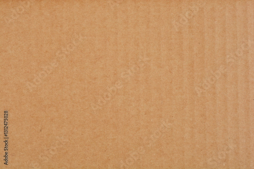 A flat surface of uniform brown cardboard fills the entire frame, showcasing its texture and color