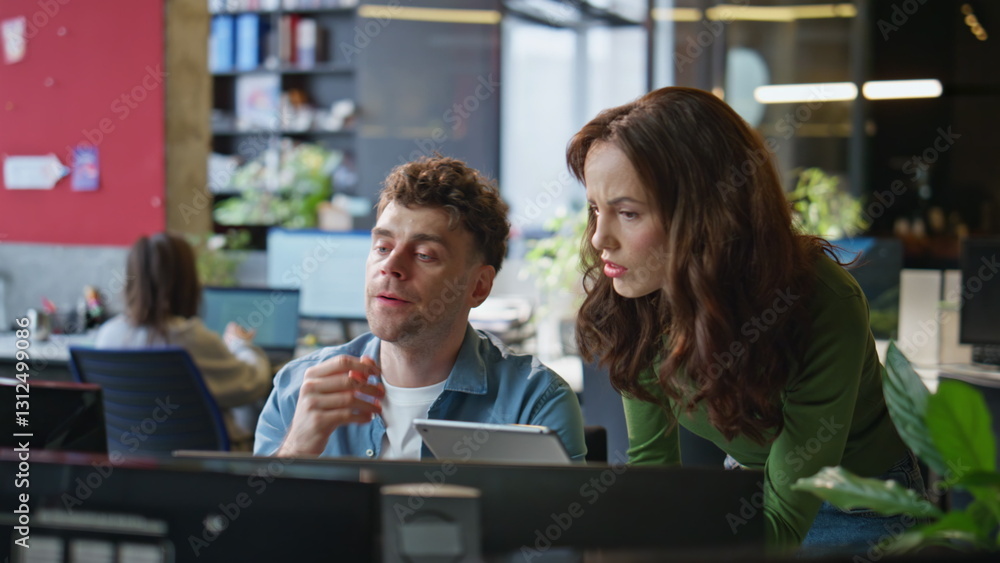 Serious office couple brainstorming task working together at computer closeup Serious office couple brainstorming task working together at computer closeup