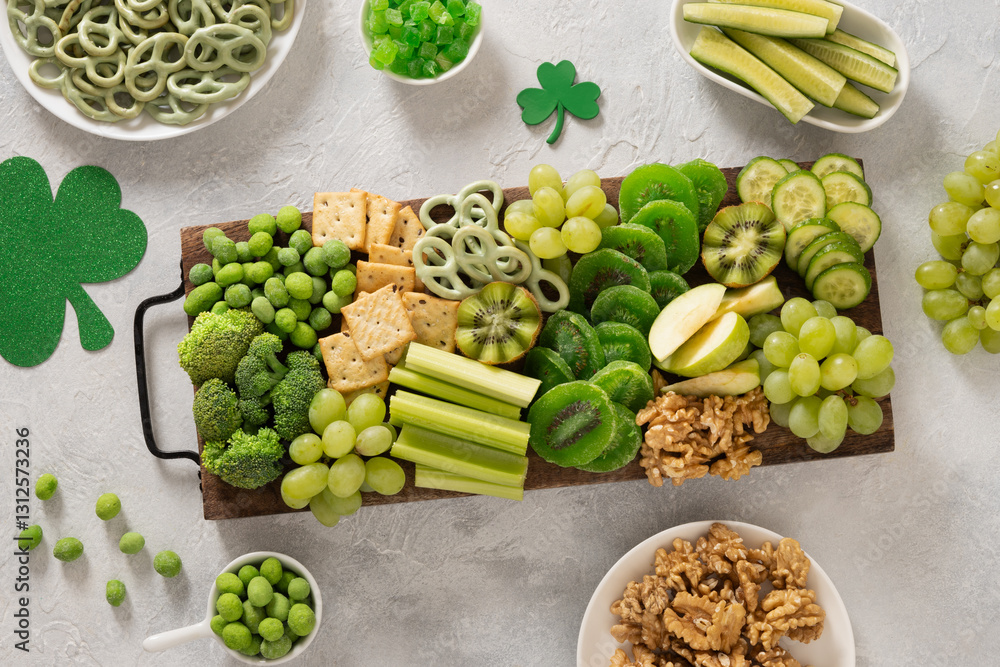 St. Patrick's Day Inspired Snacks charcuterie board with fresh vegetables decorated traditional green clover leaves on light background. Festive holiday appetizer. Top view