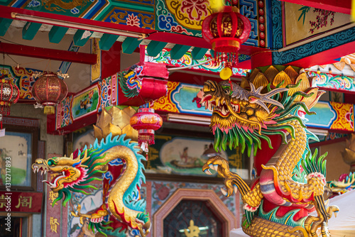 Obraz na płótnie Beautiful Elegant double golden dragon statue on the roof of on a temple for Chinese New Year Festival at Chinese shrine with blue sky. w salonie