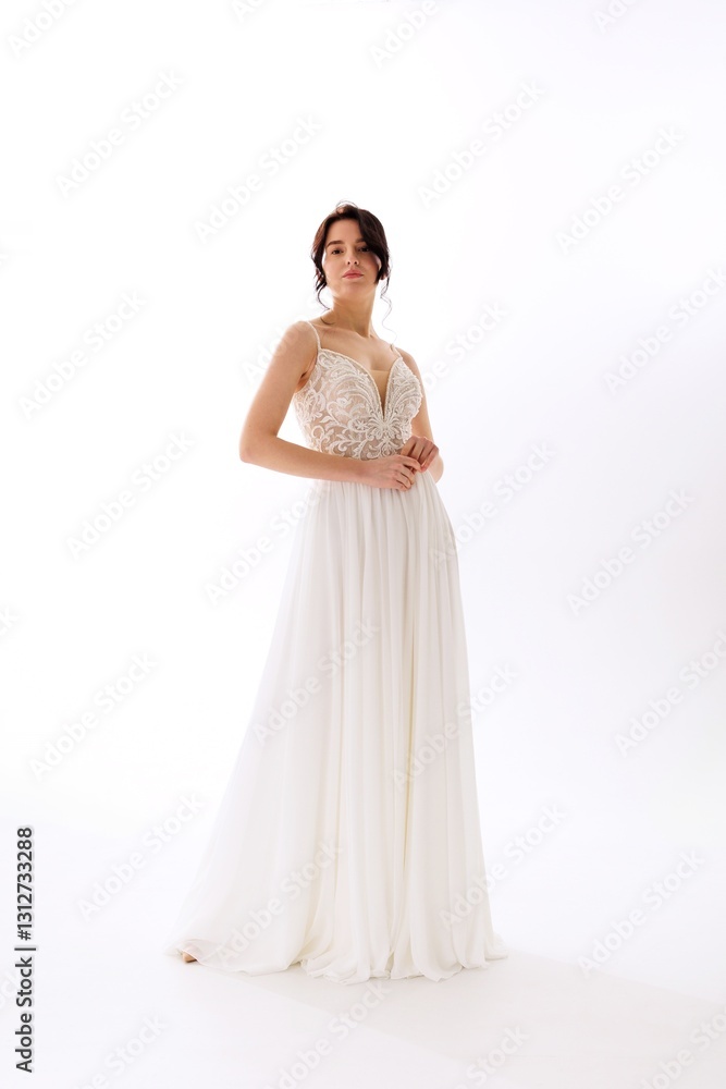 Elegant bridal gown displayed by a model in a studio setting during daylight hours Elegant bridal gown displayed by a model in a studio setting during daylight hours