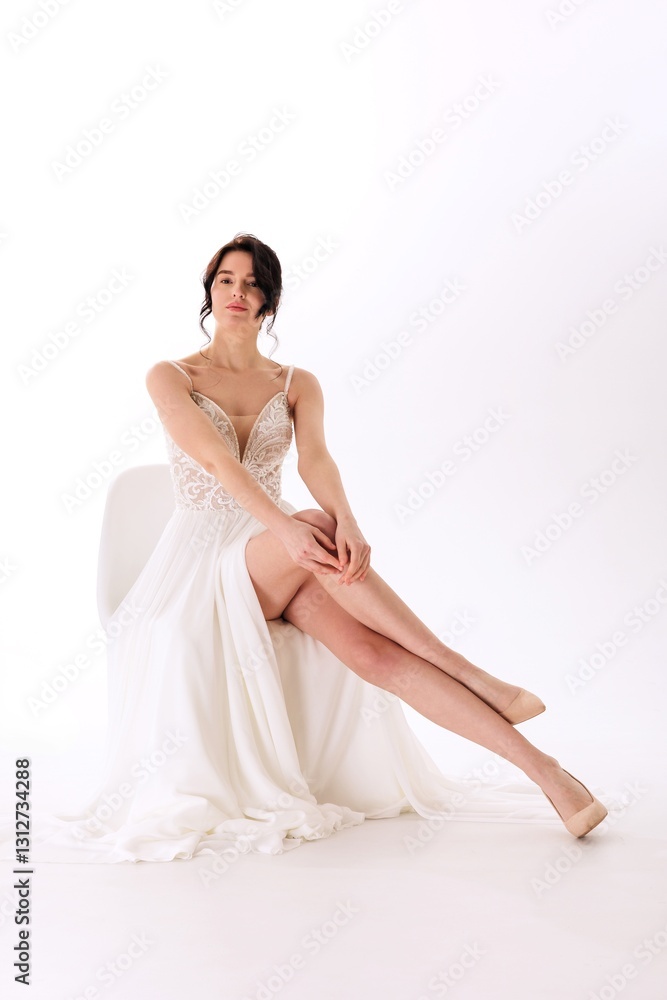 Beautiful bride in elegant white dress poses gracefully in studio setting showcasing intricate lace and flowing fabric Beautiful bride in elegant white dress poses gracefully in studio setting showcasing intricate lace and flowing fabric