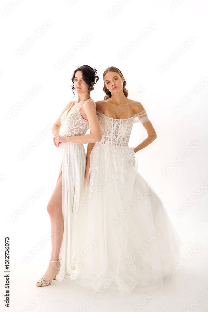 Two models showcase elegant bridal gowns against a simple white background during a fashion photoshoot Two models showcase elegant bridal gowns against a simple white background during a fashion photoshoot