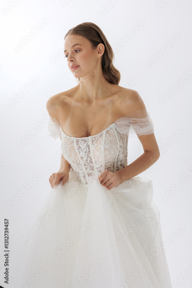 Elegant bridal model showcases stunning wedding gown in minimalist studio setting with soft lighting Elegant bridal model showcases stunning wedding gown in minimalist studio setting with soft lighting