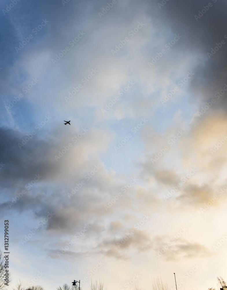 airplane flying through cloudy sky at dusk. airplane flying through cloudy sky at dusk.