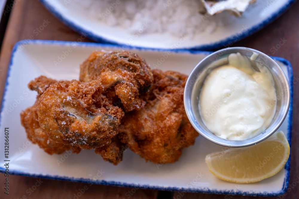 Golden fried oysters with tartar sauce served as an appetizer at a California coastal restaurant Golden fried oysters with tartar sauce served as an appetizer at a California coastal restaurant
