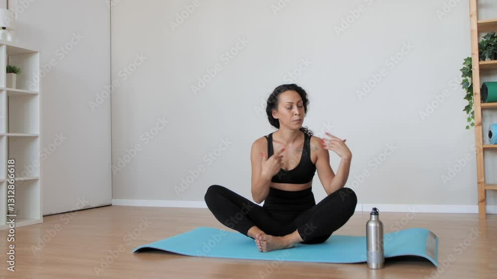 Woman opening water bottle during yoga practice Woman opening water bottle during yoga practice