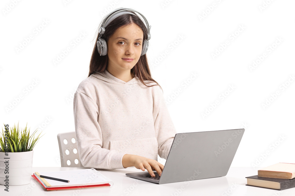 Teenage female student with headphones using a laptop computer