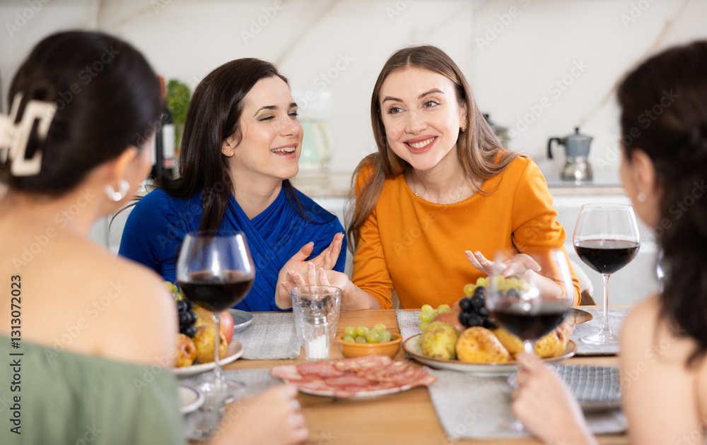 Group of women friends talking and drinking wine at party in kitchen Group of women friends talking and drinking wine at party in kitchen
