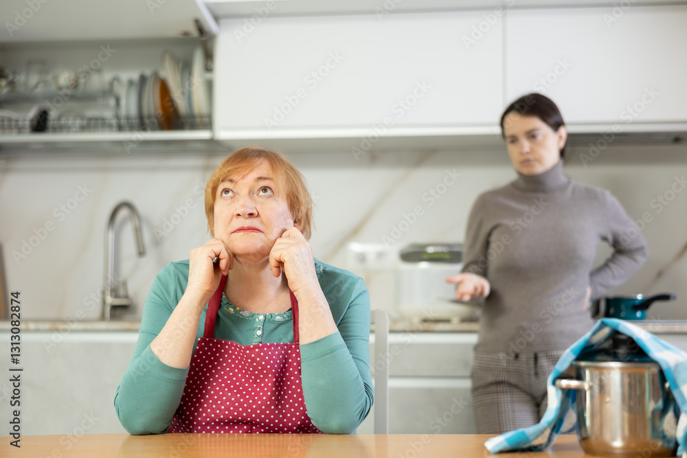 Φωτογραφία Tired of working in kitchen,sorry mother in apron listens to her daughter s indi