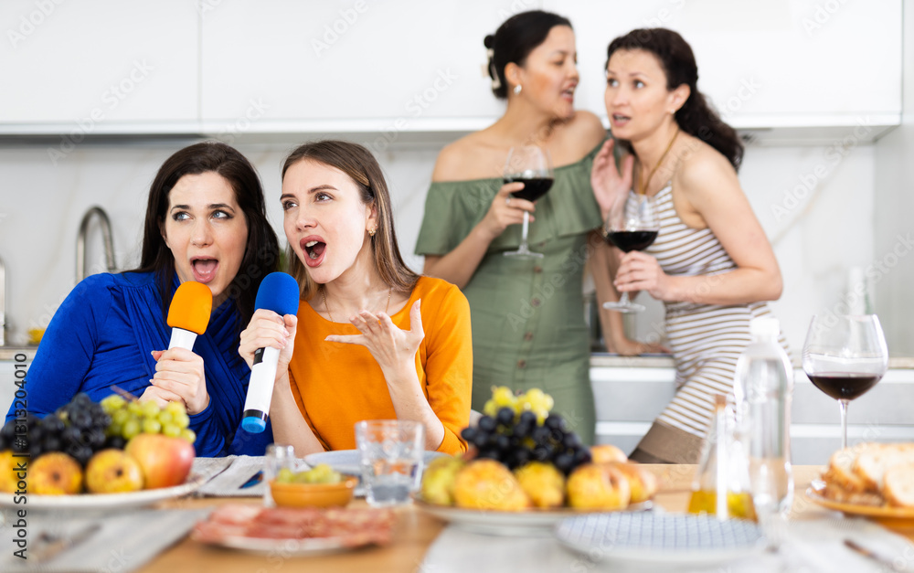Group of girlfriends singing karaoke with microphone at party at home.. Group of girlfriends singing karaoke with microphone at party at home..