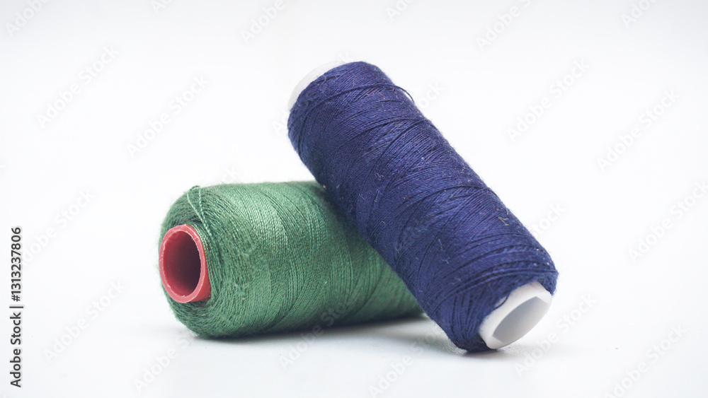Green and blue navy spool of sewing thread isolated on white background Green and blue navy spool of sewing thread isolated on white background
