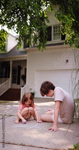 Barefoot Children Playing Tic-Tac-Toe with Chalk on Driveway – Fun Outdoor Summer Activity in Suburban Neighborhood. Carefree Summer Days