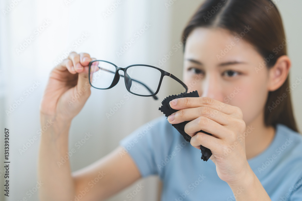 Cleaning glasses concept, close up hand of asian young woman hand holding frame of glass, use cloth wipe the lens, rub to clean eyewear for sanitary with wipe remove dust and disinfect at spectacle. Cleaning glasses concept, close up hand of asian young woman hand holding frame of glass, use cloth wipe the lens, rub to clean eyewear for sanitary with wipe remove dust and disinfect at spectacle.