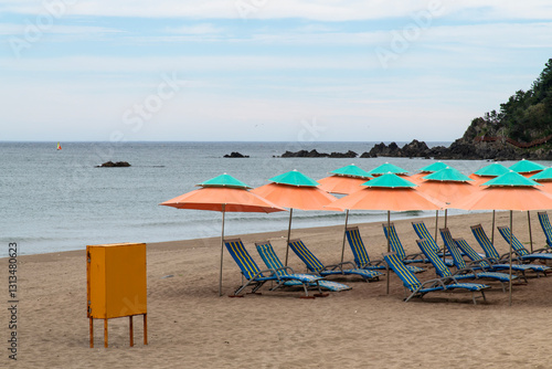 parasols and seats at the beach on a cloudy day