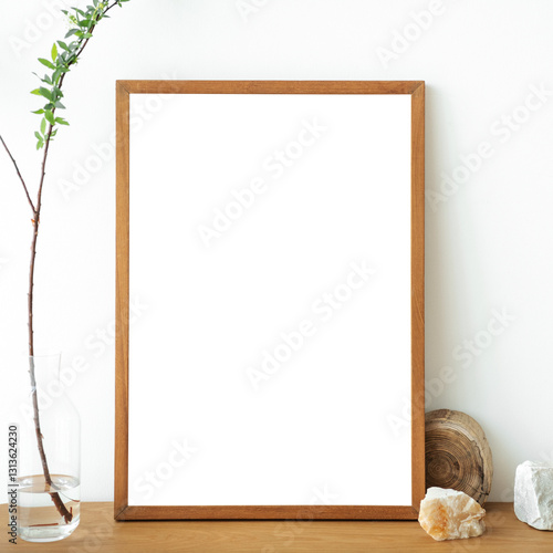 Blank wooden picture frame against a white wall design element