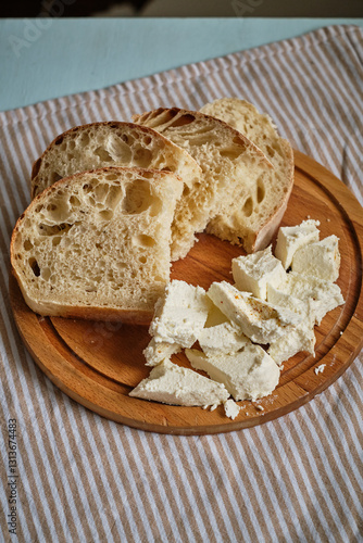 Fotografie Sliced homemade bread and homemade cheese on a wooden board