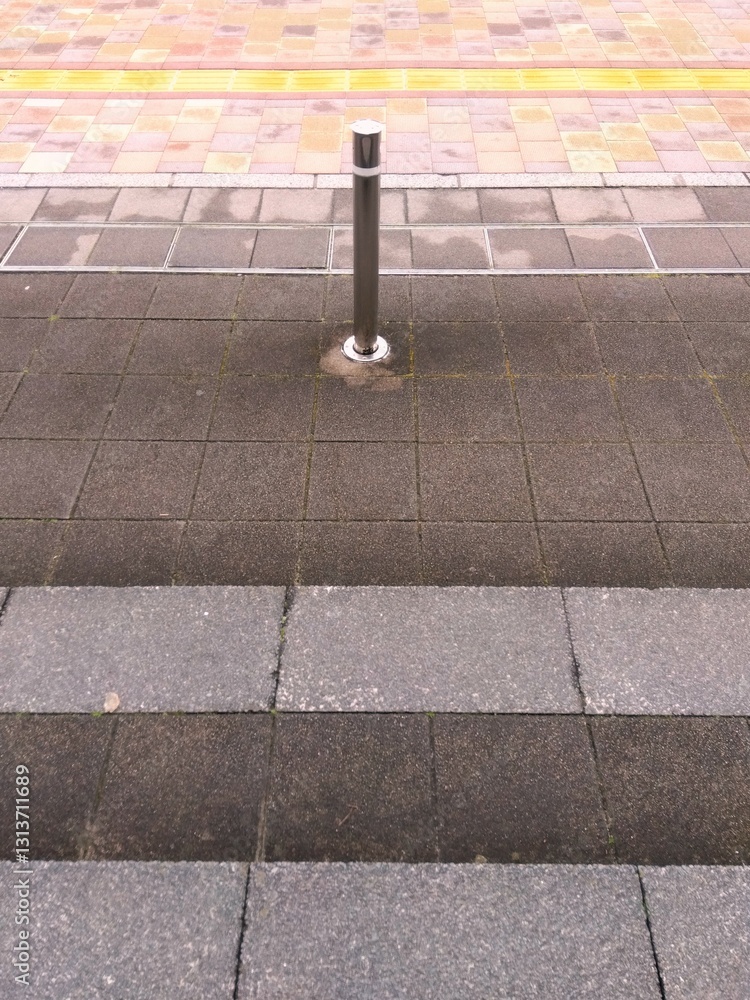 Φωτογραφία 早春の雨上がりの乾き始めた点字ブロックのある石畳の舗道風景