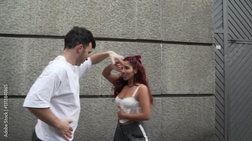 Energetic couple performing latin dance routine on urban street