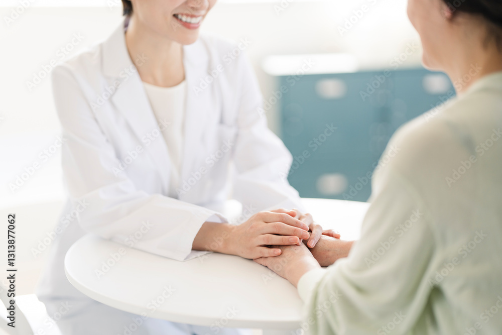 白衣を着た女性が患者の話を聞いている。
